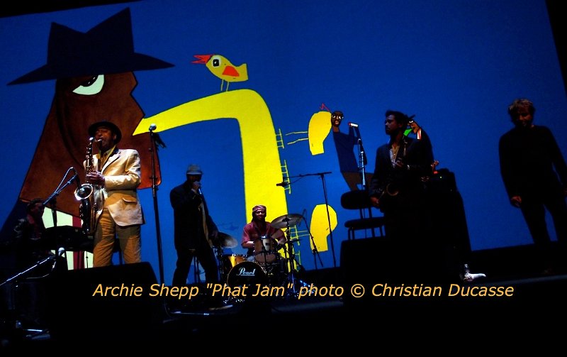 28-Shepp.PhatJam.VilletteJazz.11_byDucasse.0819.jpg - Archie Shepp sur grand écran. Beau récital façon revue dessinée par Wozniak. Les tambours d'Hamid Drake constituent un soubassement riche pour les voix déchirées d'Archie : chants et saxophones.