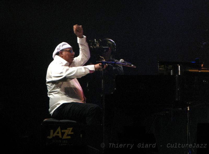 ChuchoValdes_28mai2011_w.jpg - En 1989, le pianiste Chucho Valdès avait déchaîné le public coutançais avec la formation légendaire qu'il dirigeait alors : "Irakere".De retour avec ses "Afro Jazz Messengers", il a confirmé que son encyclopédisme pianistique virtuose (de Bach à Zawinul et au-delà...) reste au service d'une musique particulièrement vivante, sans facilités... (T.G.)