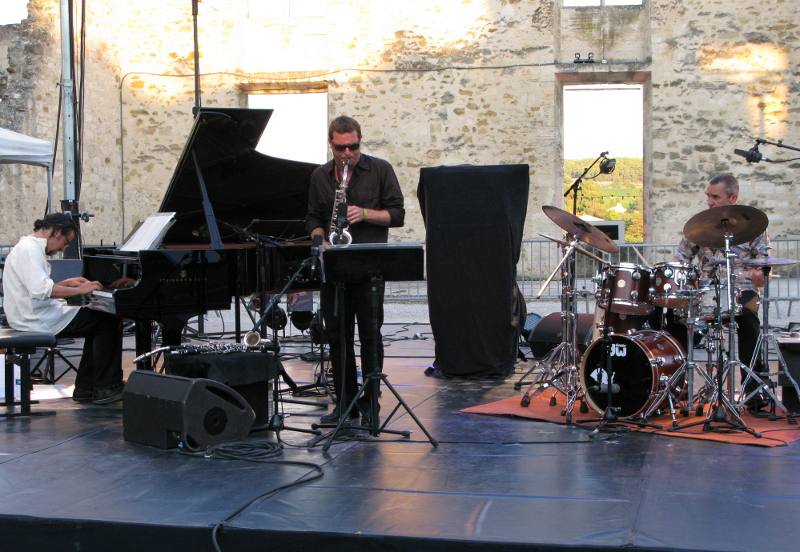 Angelini-Bruno_Trio_JALT_14aout2012_03.JPG - Est-ce le contexte particulier du concert en début de soirée ? La musique jouée par ce trio en tous points remarquable ne nous a pas vraiment touché ce soir-là... En introduction, Bruno Angelini a tenu à expliquer la trame narrative qui sous-tend ses compositions enchaînées sans pause (parcours de vie sociale de Raws, personnage qui vit les tourmentes du XXème siècle...)... c'était peut-être un obstacle à l'écoute d'une musique qui ne se veut pas desciptive mais synthétise des émotions, des révoltes, des impressions...